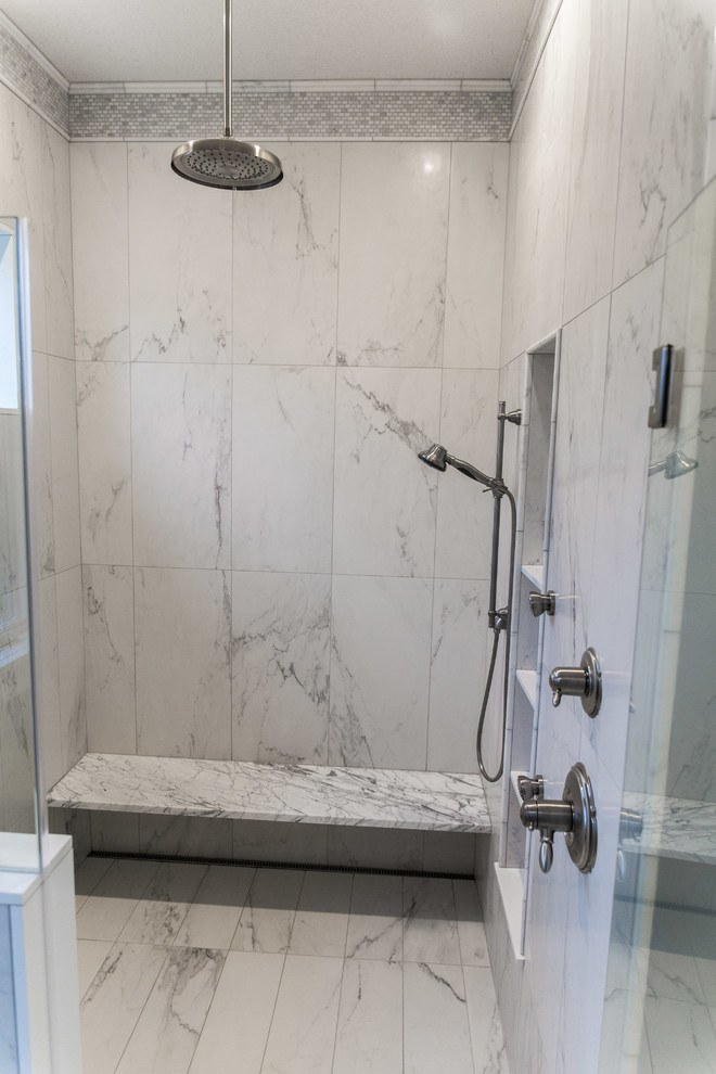 This is an example of a large traditional ensuite bathroom in New York with recessed-panel cabinets, white cabinets, a built-in shower, a one-piece toilet, white tiles, porcelain tiles, blue walls, porcelain flooring, a submerged sink and marble worktops.