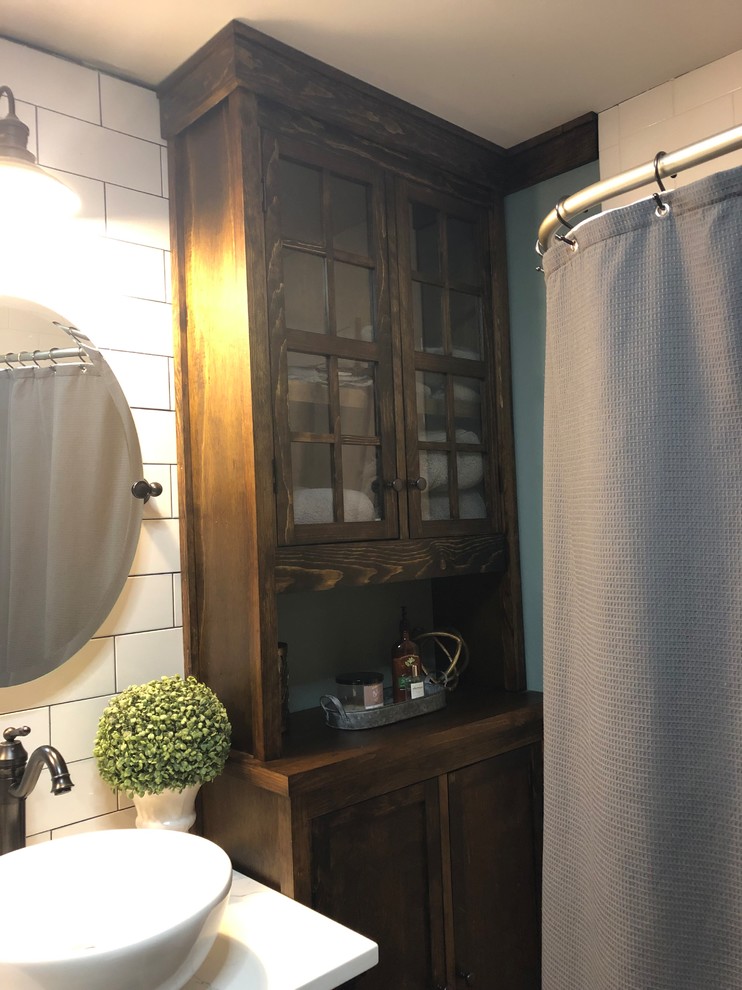 Idéer för att renovera ett mellanstort lantligt vit vitt en-suite badrum, med möbel-liknande, skåp i mörkt trä, ett hörnbadkar, en dusch/badkar-kombination, en toalettstol med hel cisternkåpa, vit kakel, tunnelbanekakel, blå väggar, mörkt trägolv, ett fristående handfat, bänkskiva i kvarts, brunt golv och dusch med duschdraperi