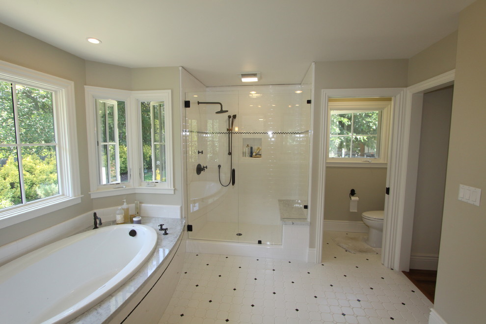 На фото: огромная главная ванная комната в классическом стиле с накладной ванной, душем в нише, мраморной столешницей, белой плиткой, керамогранитной плиткой, желтыми стенами и полом из керамической плитки