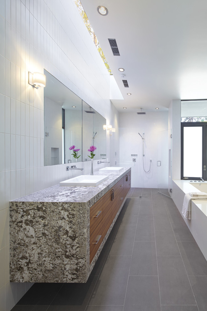 Large contemporary ensuite bathroom in San Francisco with a built-in sink, flat-panel cabinets, medium wood cabinets, granite worktops, a submerged bath, a built-in shower, a wall mounted toilet, white tiles, porcelain tiles, white walls and porcelain flooring.