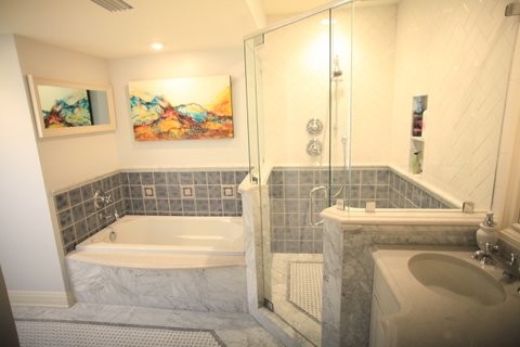 Cette image montre une salle de bain principale traditionnelle de taille moyenne avec un placard à porte plane, des portes de placard blanches, une baignoire posée, une douche d'angle, WC séparés, un carrelage gris, un carrelage de pierre, un mur gris, un sol en carrelage de terre cuite, un lavabo encastré et un plan de toilette en marbre.