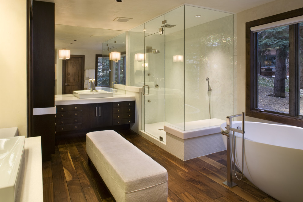 Modelo de cuarto de baño minimalista con lavabo sobreencimera, armarios con paneles lisos, puertas de armario de madera en tonos medios, bañera exenta, ducha esquinera, baldosas y/o azulejos blancos y baldosas y/o azulejos en mosaico