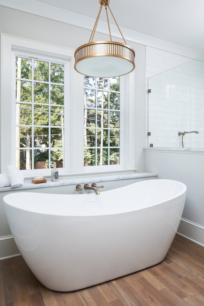 Mittelgroßes Klassisches Badezimmer En Suite mit freistehender Badewanne, beiger Wandfarbe und braunem Holzboden in Charlotte