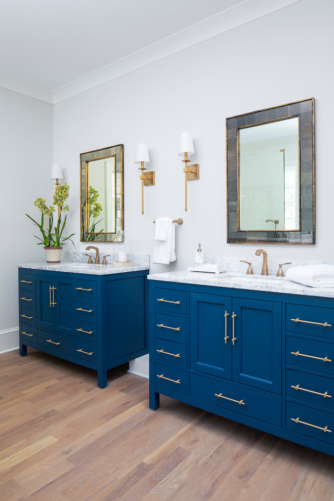 Ispirazione per una stanza da bagno padronale chic di medie dimensioni con consolle stile comò, ante blu, pareti beige, pavimento in legno massello medio e top in marmo