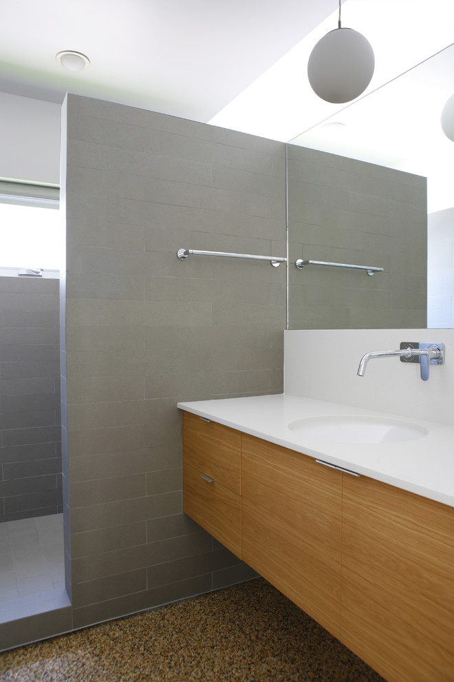 Modernes Badezimmer mit flächenbündigen Schrankfronten, hellbraunen Holzschränken, grauen Fliesen, Duschnische, weißer Wandfarbe, Unterbauwaschbecken und offener Dusche in Los Angeles
