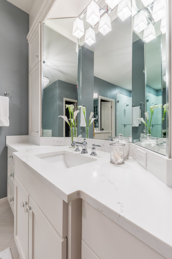 Example of a mid-sized transitional master white tile and ceramic tile porcelain tile corner shower design in Austin with shaker cabinets, white cabinets, an undermount tub, gray walls, an undermount sink and quartz countertops