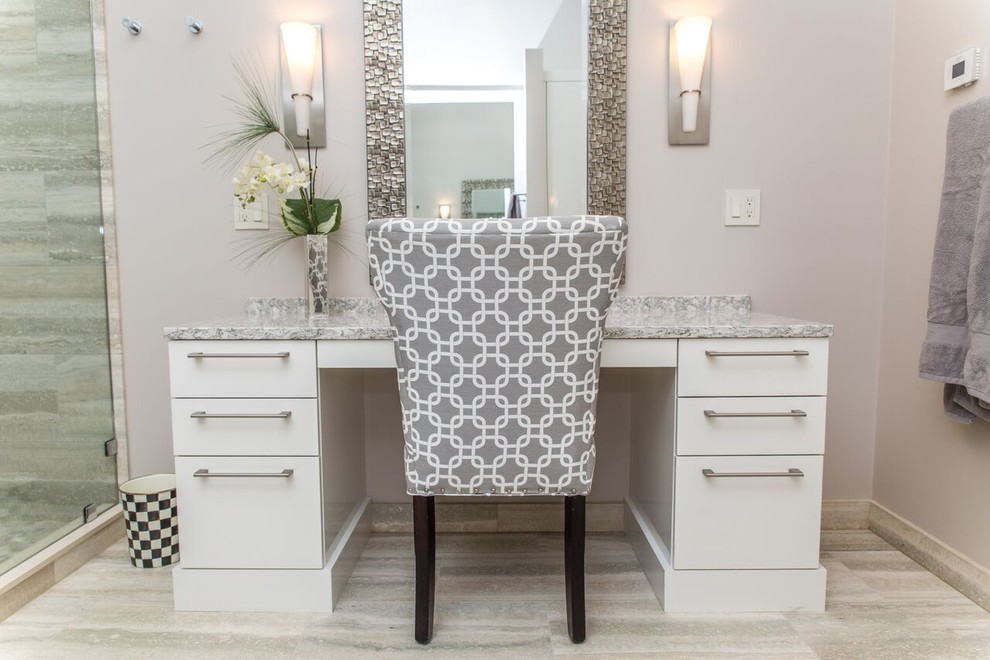 Cette image montre une salle de bain traditionnelle avec un placard à porte plane, des portes de placard blanches, un carrelage gris, un mur gris et un plan de toilette gris.