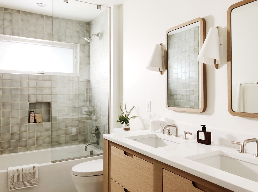 Идея дизайна: ванная комната в современном стиле с плоскими фасадами, светлыми деревянными фасадами, ванной в нише, душем над ванной, серой плиткой, душевой кабиной, врезной раковиной и душем с раздвижными дверями