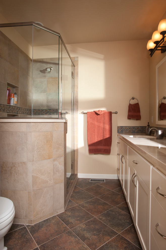 Ispirazione per una stanza da bagno padronale classica con ante in stile shaker, doccia ad angolo, WC monopezzo, piastrelle beige, pareti beige, pavimento in gres porcellanato e lavabo sottopiano