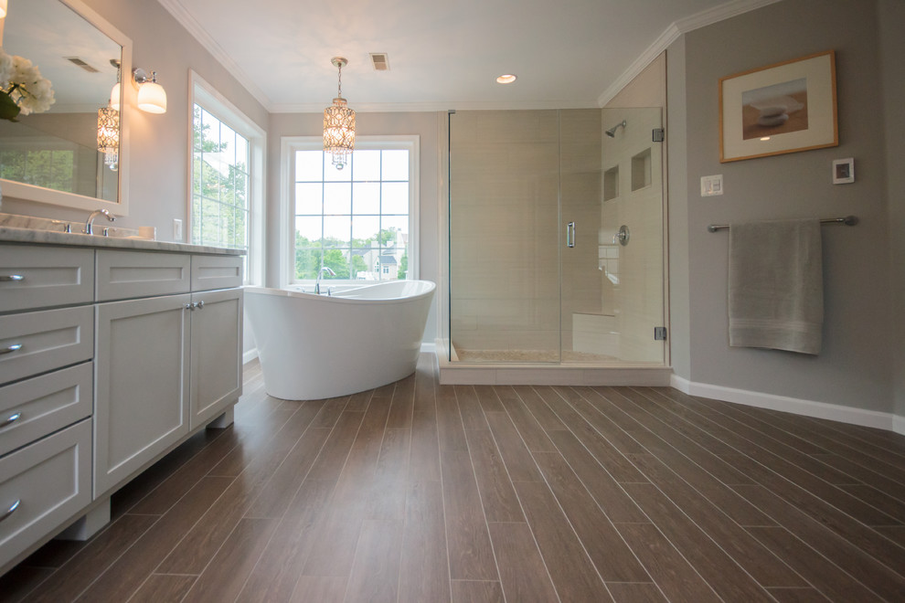 This is an example of a medium sized contemporary ensuite bathroom in Baltimore with recessed-panel cabinets, white cabinets, a freestanding bath, a corner shower, brown tiles, porcelain tiles, porcelain flooring, a submerged sink and quartz worktops.