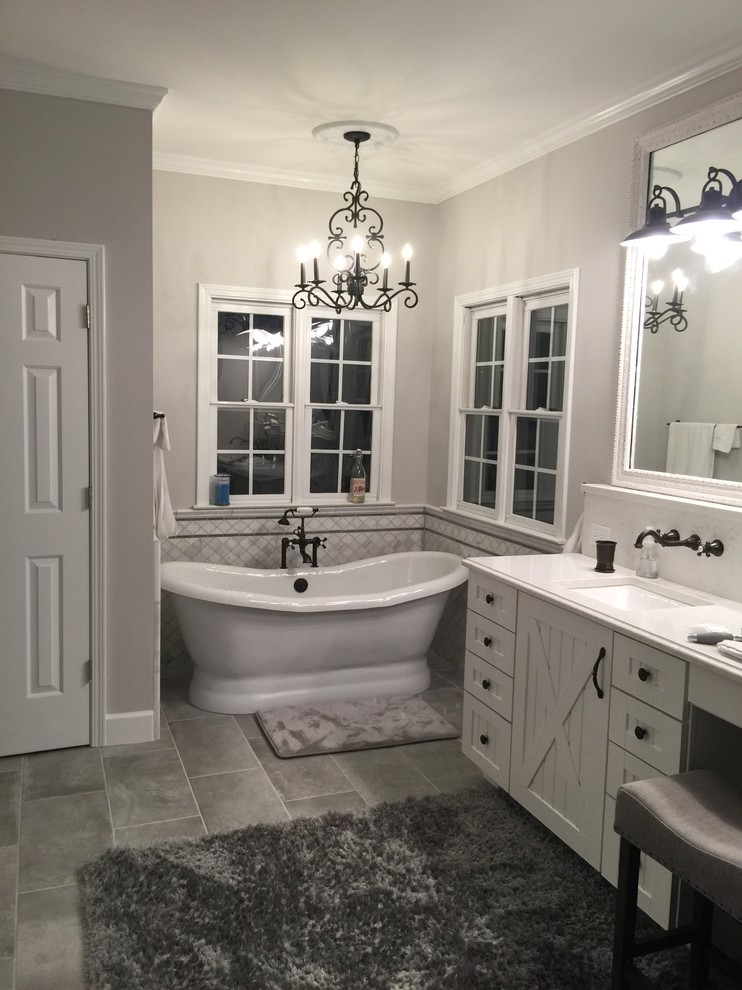 Стильный дизайн: главная ванная комната в стиле кантри с белыми фасадами, отдельно стоящей ванной, белой плиткой, мраморной плиткой, серыми стенами, полом из керамической плитки, врезной раковиной, столешницей из искусственного кварца и серым полом - последний тренд