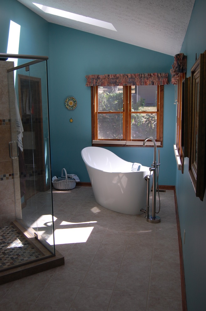 Modelo de cuarto de baño principal contemporáneo grande con armarios con paneles empotrados, puertas de armario de madera en tonos medios, bañera exenta, ducha esquinera, baldosas y/o azulejos en mosaico, paredes azules, suelo de baldosas de porcelana, lavabo bajoencimera y encimera de laminado
