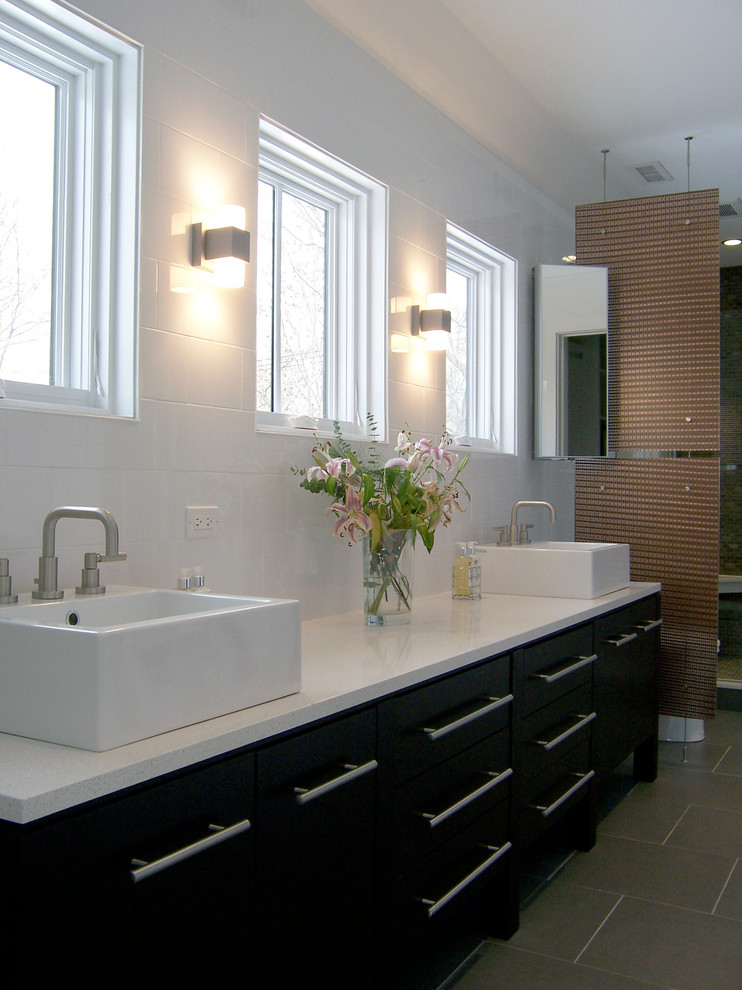 Imagen de cuarto de baño principal actual grande con armarios con paneles lisos, puertas de armario negras, paredes blancas, suelo de baldosas de porcelana, lavabo sobreencimera, encimera de cuarcita y suelo gris