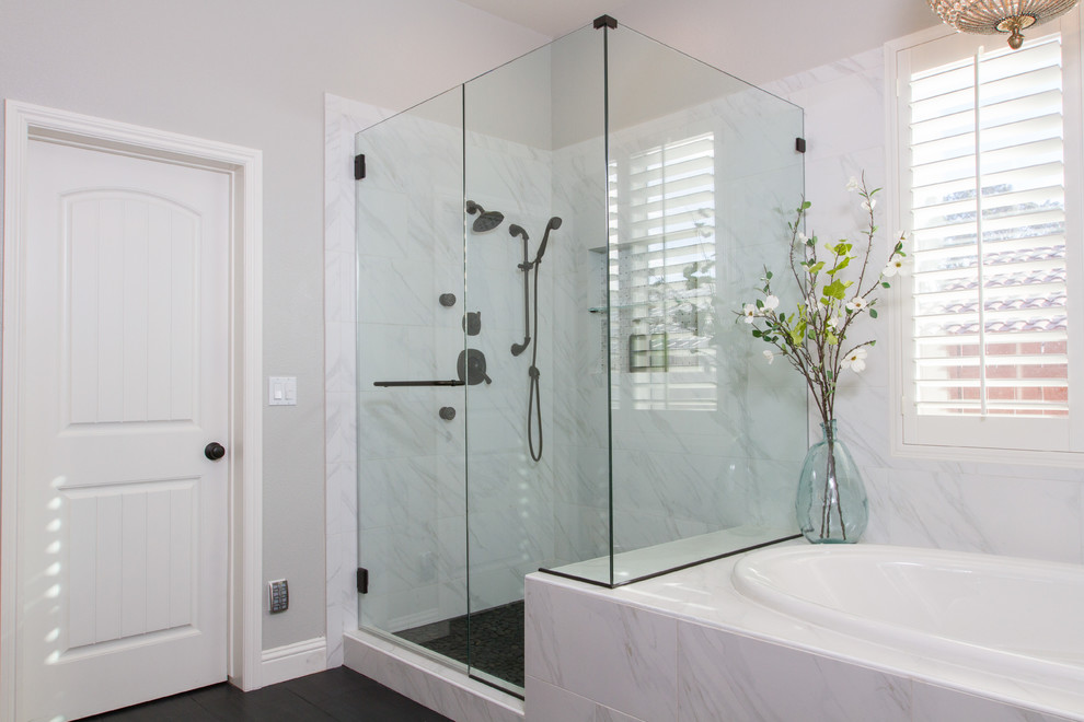 Photo of a large industrial ensuite bathroom in Santa Barbara with flat-panel cabinets, medium wood cabinets, a built-in bath, a corner shower, a two-piece toilet, white tiles, porcelain tiles, grey walls, porcelain flooring, a trough sink and concrete worktops.