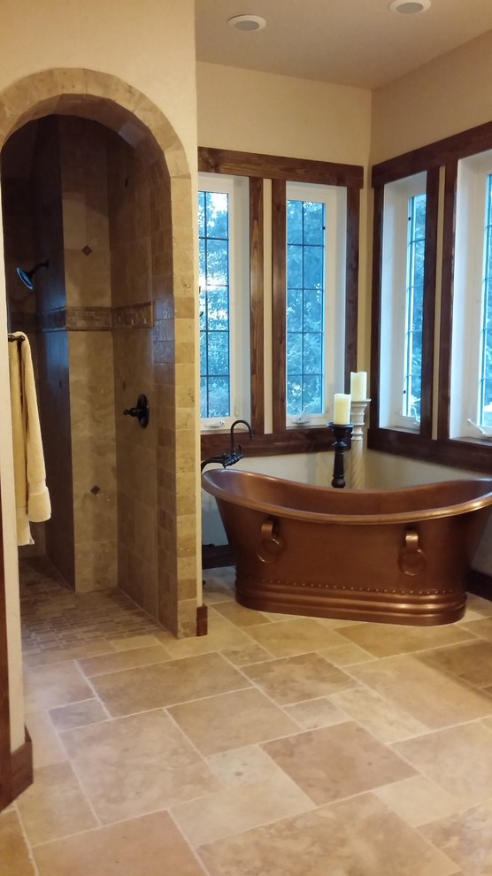 Exemple d'une salle de bain principale montagne en bois foncé de taille moyenne avec un placard avec porte à panneau surélevé, une baignoire indépendante, un carrelage beige, un mur beige, un sol en travertin, une vasque et un plan de toilette en granite.