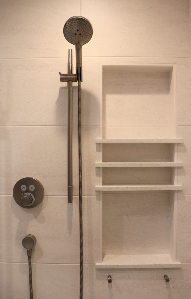 Klassisk inredning av ett en-suite badrum, med luckor med upphöjd panel, en kantlös dusch, en bidé, porslinskakel, klinkergolv i porslin, ett undermonterad handfat och bänkskiva i kvarts