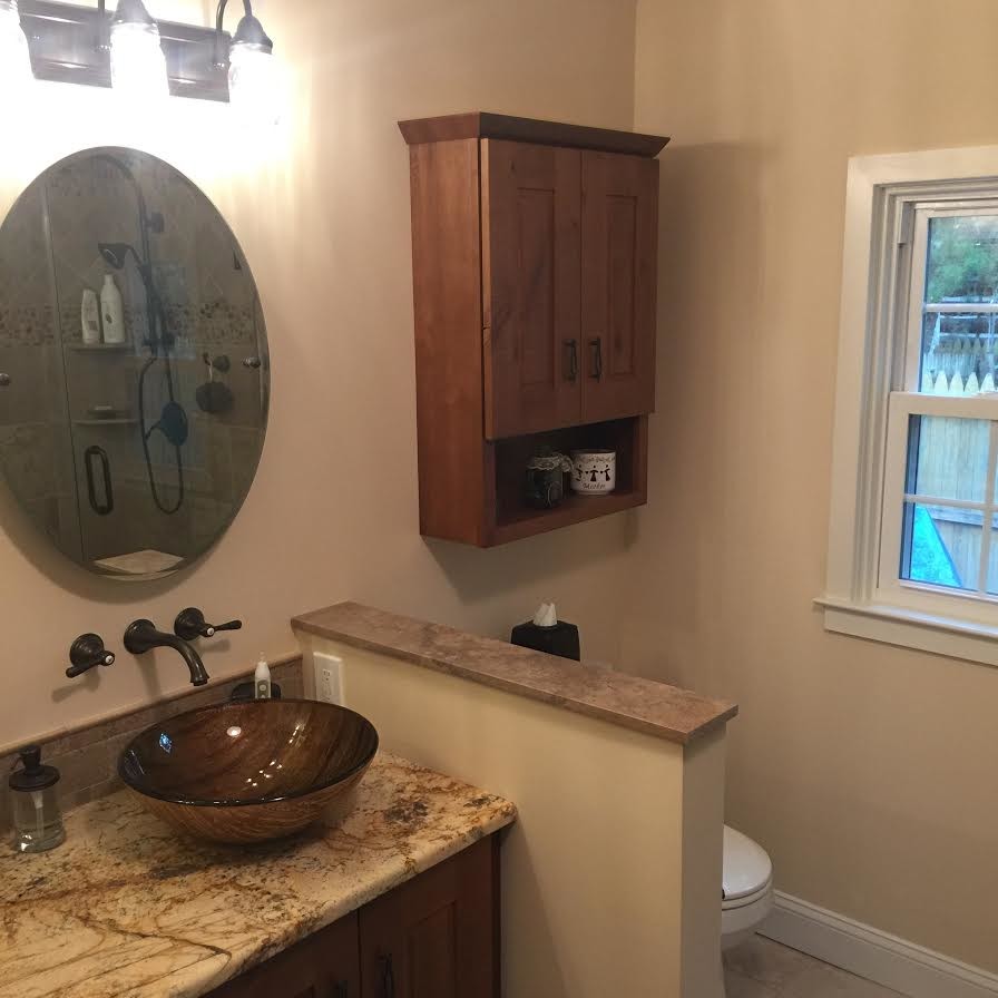 Ejemplo de cuarto de baño principal actual con puertas de armario de madera oscura, lavabo sobreencimera, encimera de granito y armarios con paneles con relieve