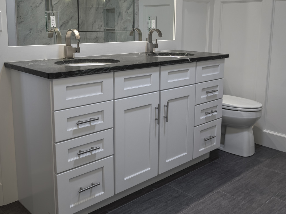 Imagen de cuarto de baño principal actual de tamaño medio con armarios estilo shaker, puertas de armario blancas, bañera exenta, paredes grises y suelo de baldosas de porcelana