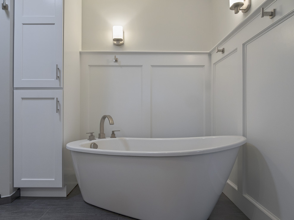 Idee per una stanza da bagno padronale minimal di medie dimensioni con ante in stile shaker, ante bianche, vasca freestanding, pareti grigie e pavimento in gres porcellanato