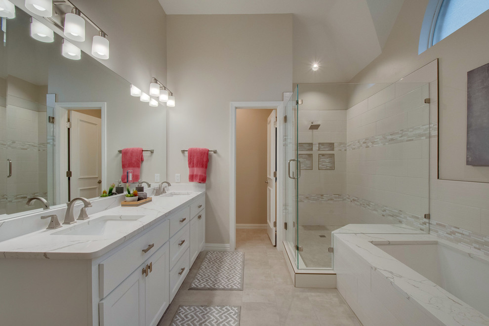 Exemple d'une grande salle de bain principale tendance avec un placard à porte shaker, des portes de placard blanches, une baignoire encastrée, une douche d'angle, WC séparés, un carrelage gris, des carreaux de céramique, un mur gris, un sol en carrelage de porcelaine, un lavabo encastré, un plan de toilette en quartz, un sol gris et une cabine de douche à porte battante.