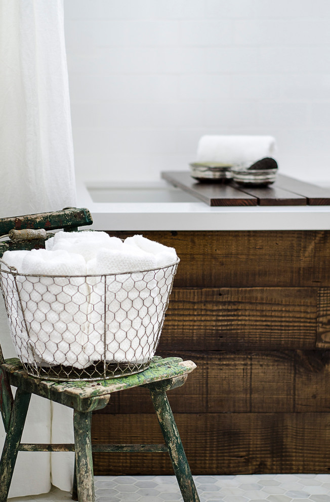Foto på ett litet vintage en-suite badrum, med ett undermonterat badkar, en dusch/badkar-kombination, en toalettstol med separat cisternkåpa, vit kakel, tunnelbanekakel, vita väggar, marmorgolv, ett nedsänkt handfat, bänkskiva i akrylsten och släta luckor