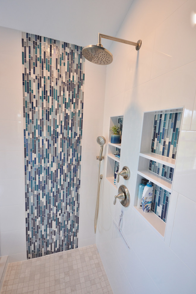 Стильный дизайн: огромная главная ванная комната в стиле неоклассика (современная классика) с фасадами с утопленной филенкой, белыми фасадами, отдельно стоящей ванной, угловым душем, унитазом-моноблоком, синей плиткой, плиткой мозаикой, синими стенами, полом из керамической плитки, врезной раковиной, столешницей из искусственного кварца, бежевым полом, душем с распашными дверями, белой столешницей, нишей, тумбой под две раковины и встроенной тумбой - последний тренд