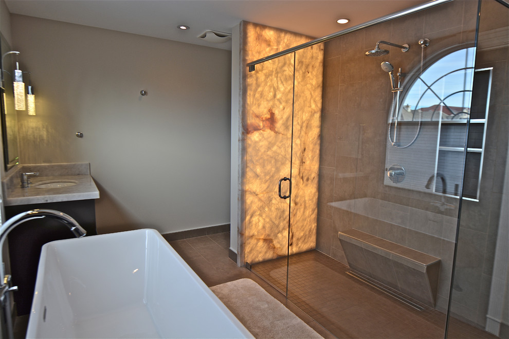 Exempel på ett modernt badrum, med släta luckor, skåp i mörkt trä, bänkskiva i onyx, porslinskakel, ett fristående badkar, en kantlös dusch, ett undermonterad handfat och klinkergolv i porslin