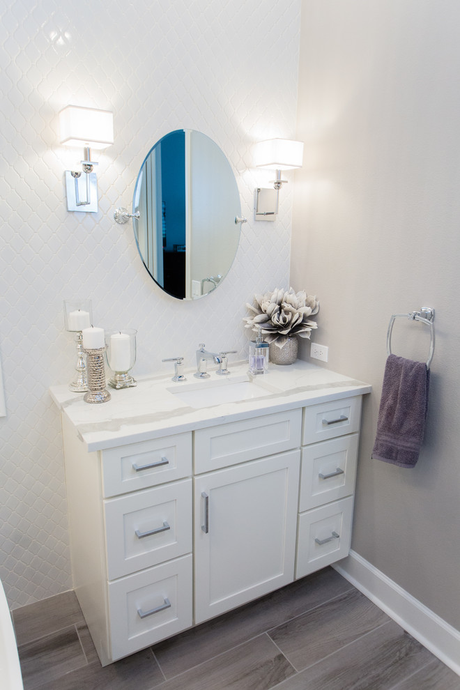 Photo of a medium sized classic ensuite bathroom in Tampa with shaker cabinets, white cabinets, a freestanding bath, an alcove shower, a one-piece toilet, white tiles, porcelain tiles, grey walls, porcelain flooring, a submerged sink, glass worktops, brown floors, a hinged door and white worktops.