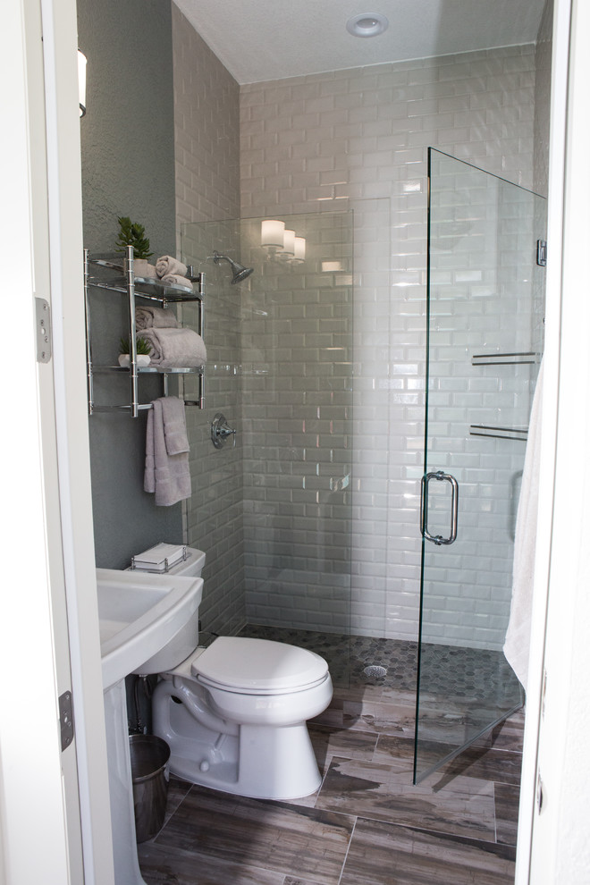 Inspiration för ett litet vintage badrum med dusch, med ett badkar med tassar, en dusch i en alkov, en toalettstol med hel cisternkåpa, grå kakel, porslinskakel, grå väggar, klinkergolv i porslin, ett piedestal handfat, brunt golv och dusch med gångjärnsdörr