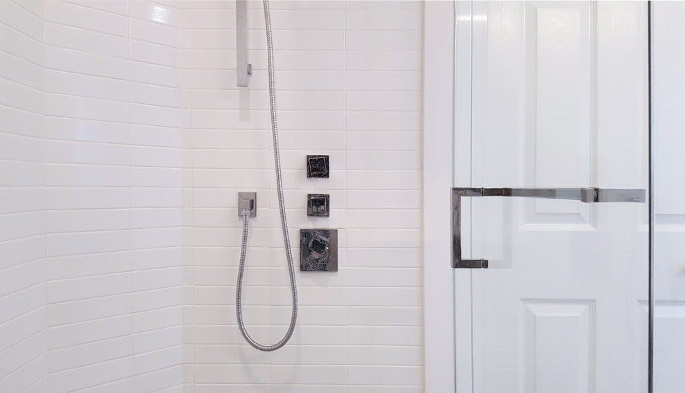 На фото: главная ванная комната среднего размера в современном стиле с отдельно стоящей ванной, угловым душем, белой плиткой, керамической плиткой, белыми стенами, душем с распашными дверями, плоскими фасадами, темными деревянными фасадами, врезной раковиной и столешницей из искусственного камня