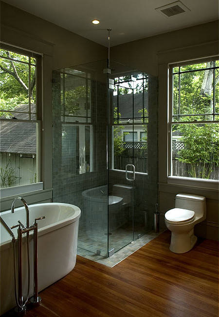 Cette photo montre une salle de bain principale craftsman en bois clair avec un lavabo posé, un placard à porte plane, un plan de toilette en granite, une baignoire indépendante, une douche d'angle, WC à poser, des carreaux de céramique et un sol en bois brun.