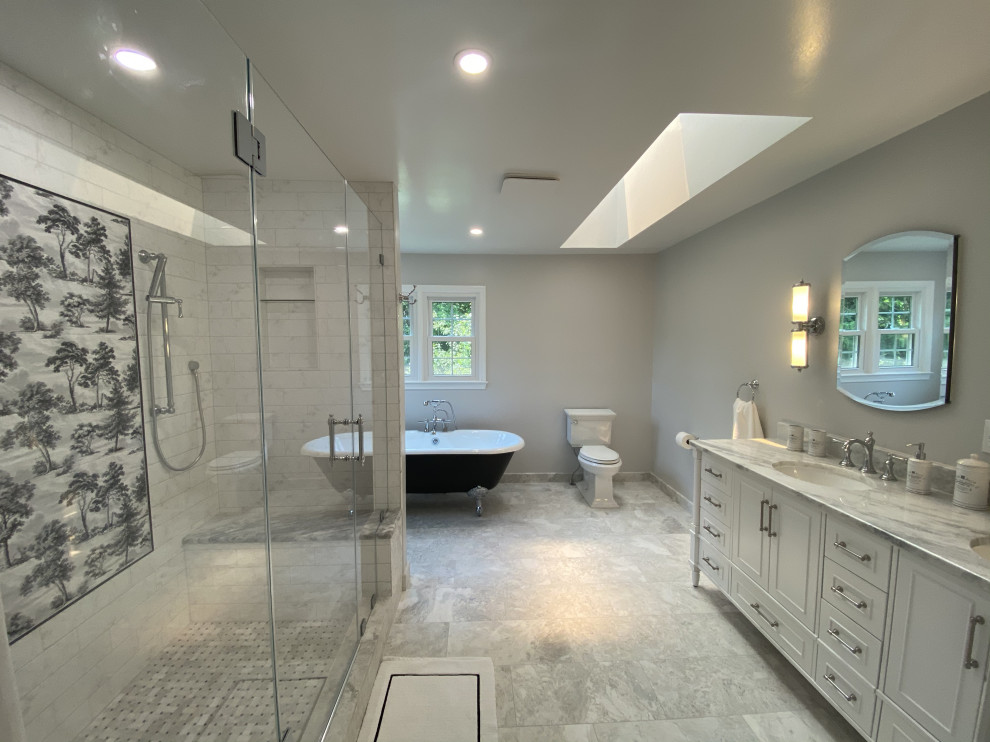 Large traditional ensuite bathroom in DC Metro with a claw-foot bath, a double shower, a two-piece toilet, grey walls, marble flooring, a built-in sink, marble worktops, grey floors, a hinged door, grey worktops, a shower bench, double sinks and a freestanding vanity unit.