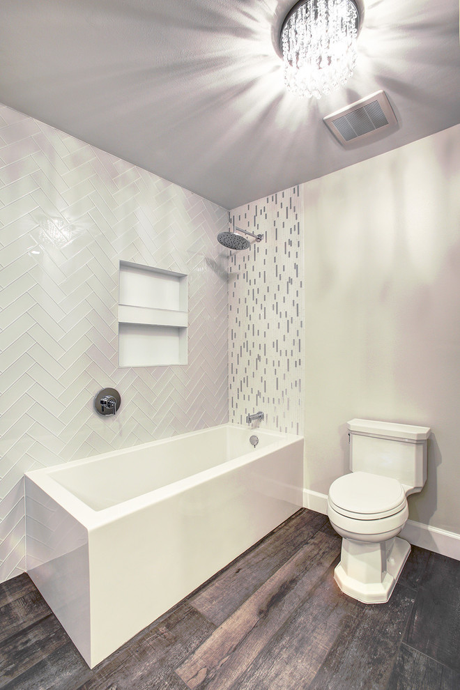 Пример оригинального дизайна: большая главная ванная комната в современном стиле с ванной в нише, душем над ванной, раздельным унитазом, серой плиткой, белой плиткой, керамогранитной плиткой, серыми стенами, темным паркетным полом, серым полом и открытым душем