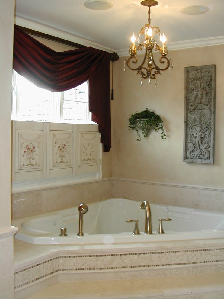 Inspiration för ett stort vintage en-suite badrum, med ett undermonterad handfat, luckor med upphöjd panel, vita skåp, marmorbänkskiva, ett hörnbadkar, beige kakel, stenkakel, beige väggar och kalkstensgolv