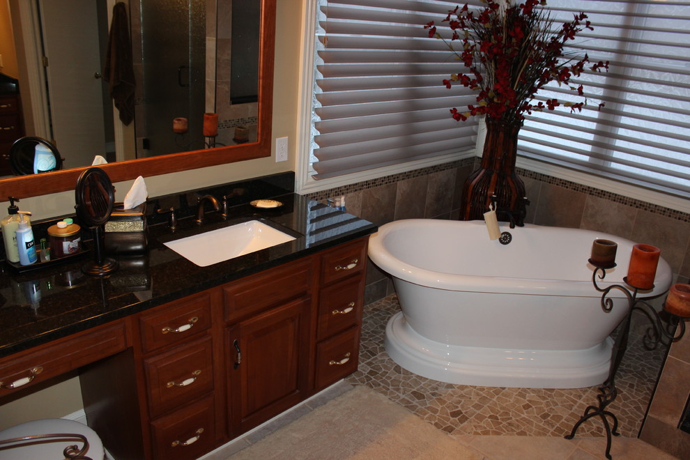 Esempio di una stanza da bagno classica con lavabo sottopiano, ante con bugna sagomata, ante in legno scuro, top in granito, vasca freestanding, doccia ad angolo, WC monopezzo e piastrelle marroni