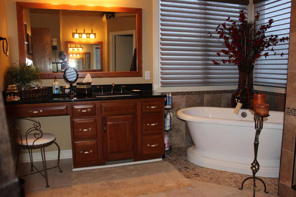 Foto di una stanza da bagno tradizionale con lavabo sottopiano, ante con bugna sagomata, ante in legno scuro, top in granito, vasca freestanding, doccia ad angolo, WC monopezzo e piastrelle marroni