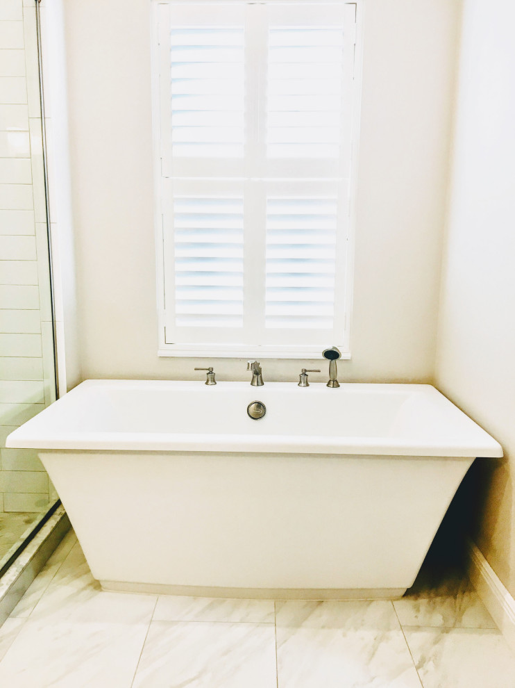 Example of a mid-sized cottage master white tile and subway tile freestanding bathtub design in Orlando with gray cabinets, solid surface countertops, a hinged shower door and white countertops