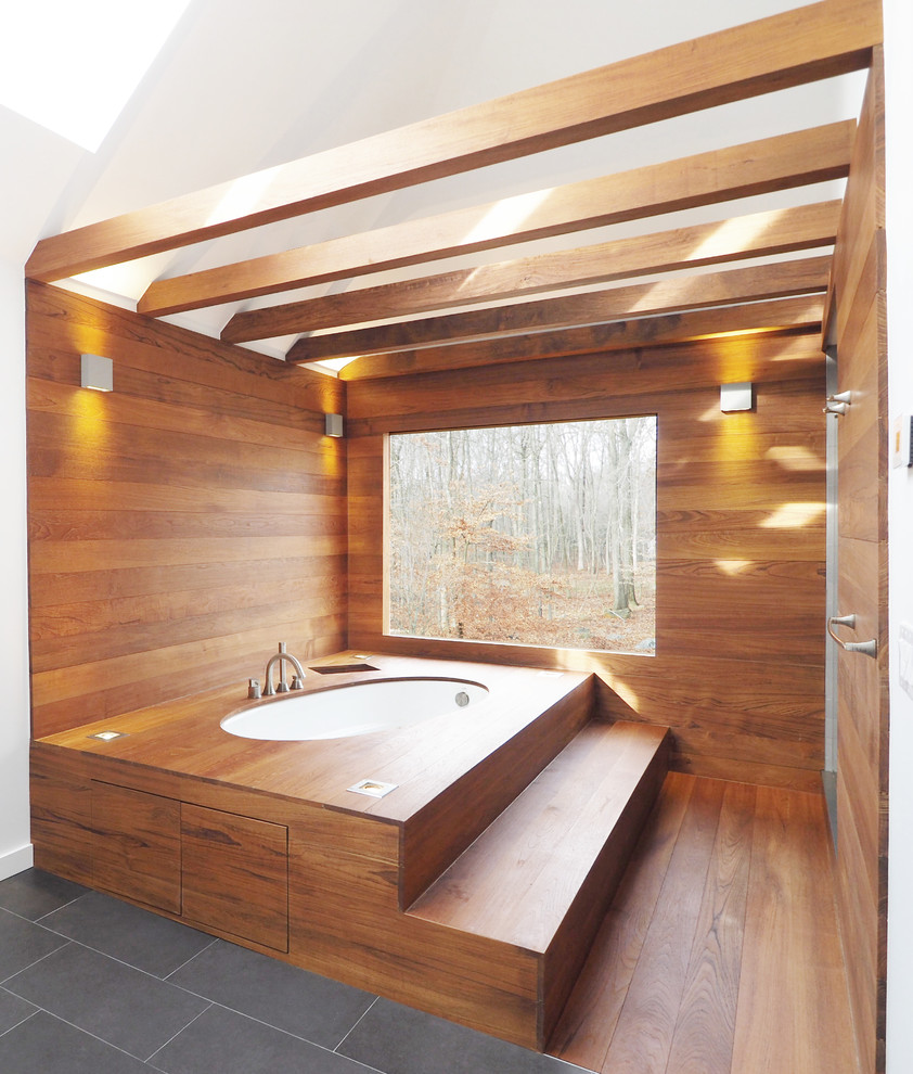 Inspiration pour une salle de bain design avec une baignoire encastrée, un mur blanc, un sol en bois brun et un sol marron.