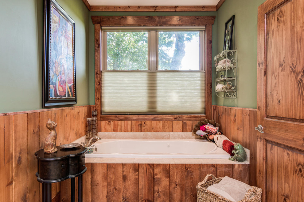 Immagine di una stanza da bagno padronale stile rurale con vasca da incasso, pareti verdi, top in granito e top nero