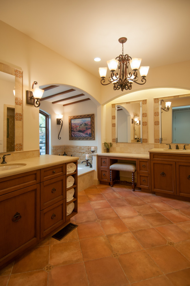 Large tuscan master beige tile and limestone tile porcelain tile, orange floor, double-sink and exposed beam bathroom photo in San Francisco with recessed-panel cabinets, medium tone wood cabinets, an undermount tub, a bidet, beige walls, an undermount sink, quartz countertops, a hinged shower door, beige countertops and a built-in vanity