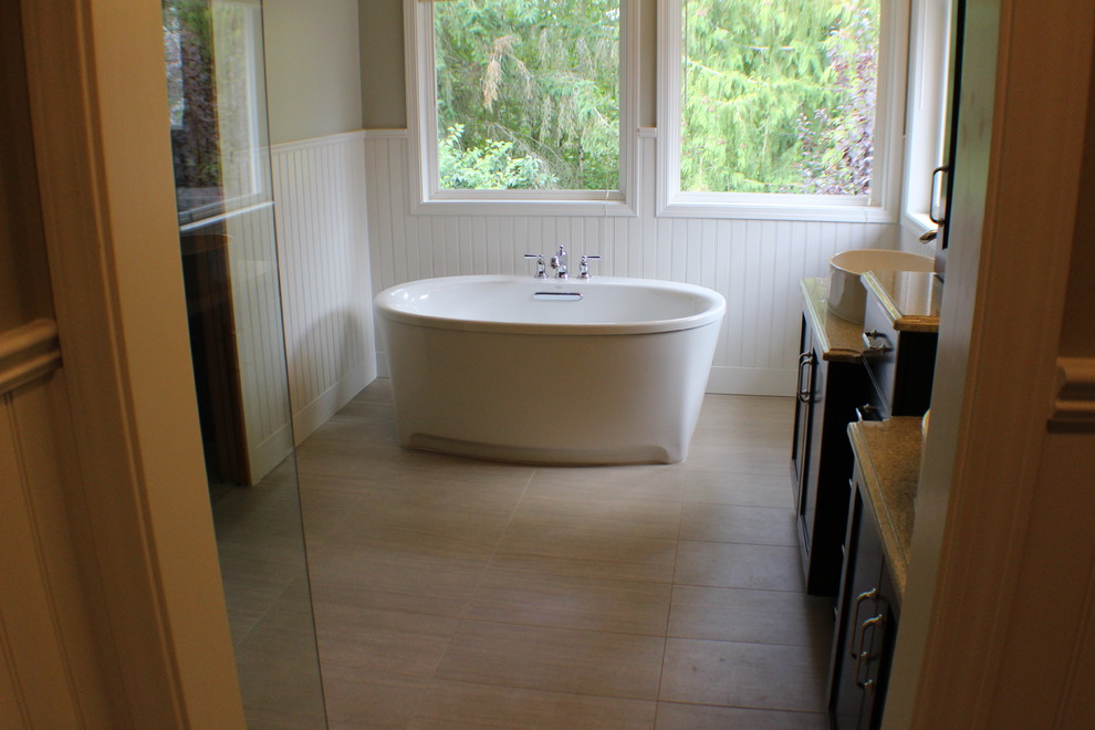 Foto på ett stort vintage beige badrum, med luckor med infälld panel, skåp i mörkt trä, ett fristående badkar, klinkergolv i porslin, ett fristående handfat, bänkskiva i kvarts och beiget golv