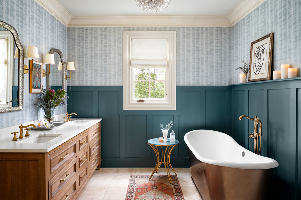 Example of a classic ceramic tile and beige floor freestanding bathtub design in Atlanta with furniture-like cabinets, light wood cabinets, an undermount sink, quartz countertops and white countertops