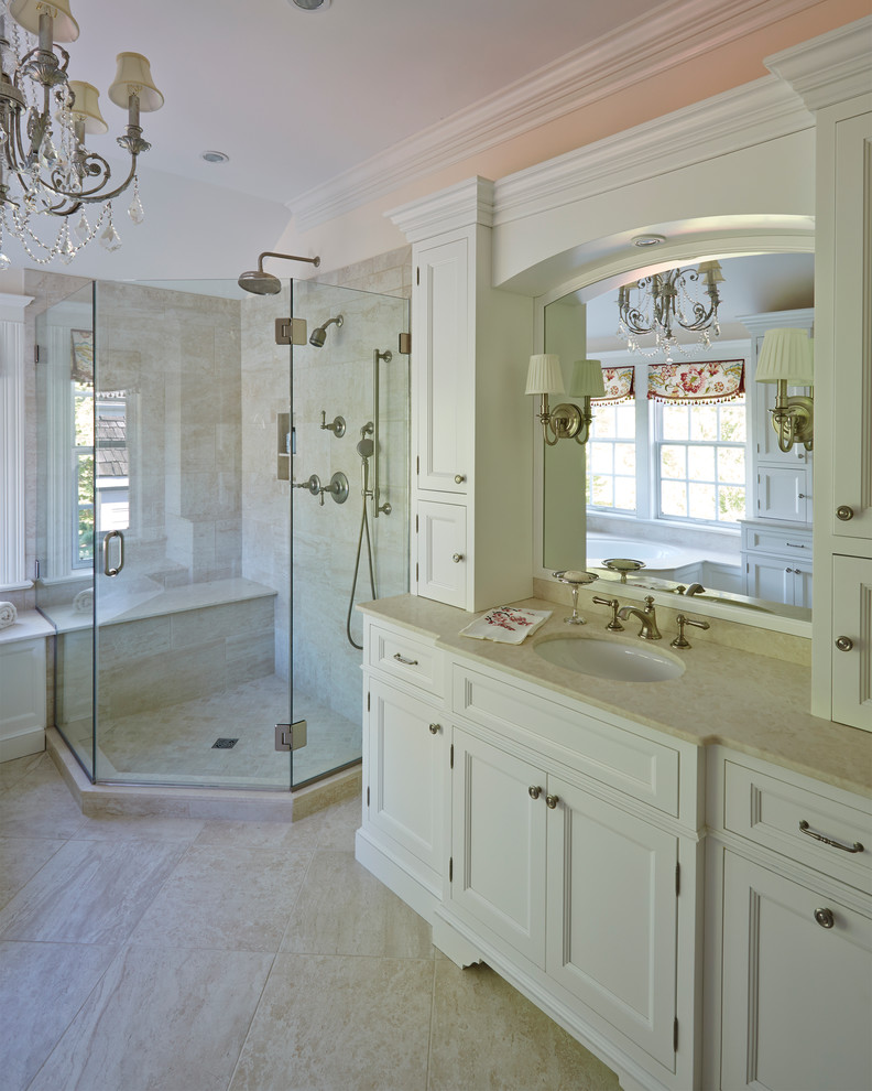 Aménagement d'une salle de bain romantique avec un lavabo encastré, un placard avec porte à panneau encastré, des portes de placard blanches, une baignoire d'angle, une douche d'angle et un mur beige.