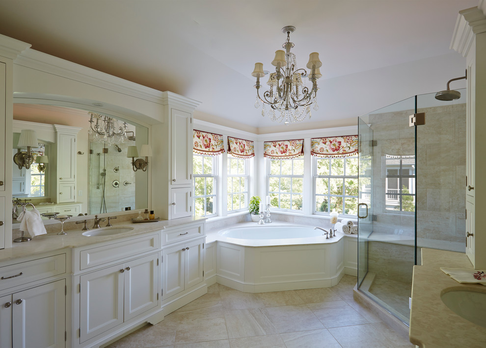 Immagine di una stanza da bagno stile shabby con lavabo sottopiano, ante con riquadro incassato, ante bianche, vasca ad angolo, doccia ad angolo e pareti beige