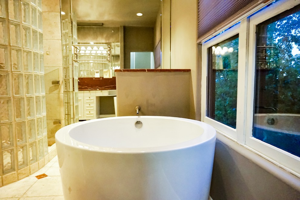 Пример оригинального дизайна: главная ванная комната среднего размера в стиле неоклассика (современная классика) с белыми фасадами, японской ванной, открытым душем, унитазом-моноблоком, бежевой плиткой, каменной плиткой, серыми стенами, полом из терраццо, настольной раковиной, мраморной столешницей, бежевым полом и душем с распашными дверями