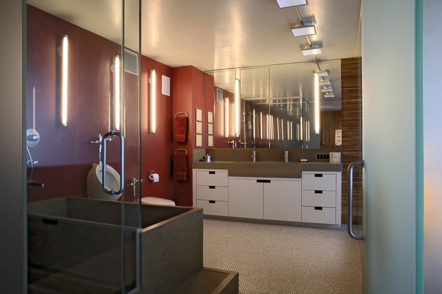 Стильный дизайн: большая главная ванная комната в современном стиле с плоскими фасадами, белыми фасадами, отдельно стоящей ванной, открытым душем, инсталляцией, красными стенами, полом из керамической плитки, монолитной раковиной, столешницей из бетона, разноцветным полом, душем с распашными дверями, серой столешницей, тумбой под две раковины, встроенной тумбой и панелями на части стены - последний тренд