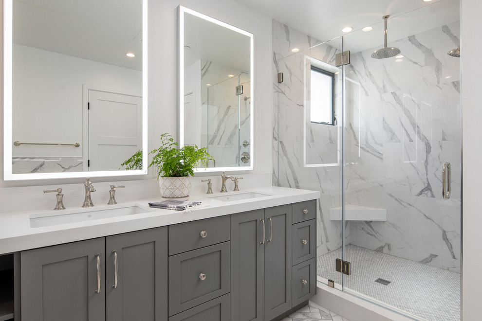 ロサンゼルスにあるトランジショナルスタイルのおしゃれな浴室 (シェーカースタイル扉のキャビネット、グレーのキャビネット、アルコーブ型シャワー、白いタイル、白い壁、アンダーカウンター洗面器、白い床、開き戸のシャワー、白い洗面カウンター) の写真