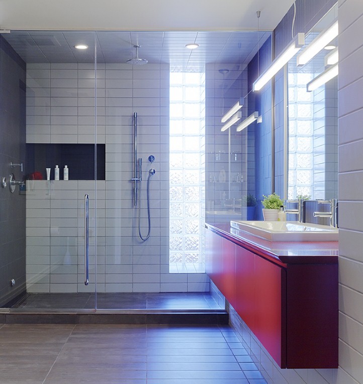 Réalisation d'une grande salle de bain design avec un lavabo posé, un placard à porte plane, des portes de placard rouges, un plan de toilette en quartz modifié, une douche double, un carrelage gris, des carreaux de porcelaine, un mur blanc, un sol en carrelage de porcelaine et un plan de toilette rouge.