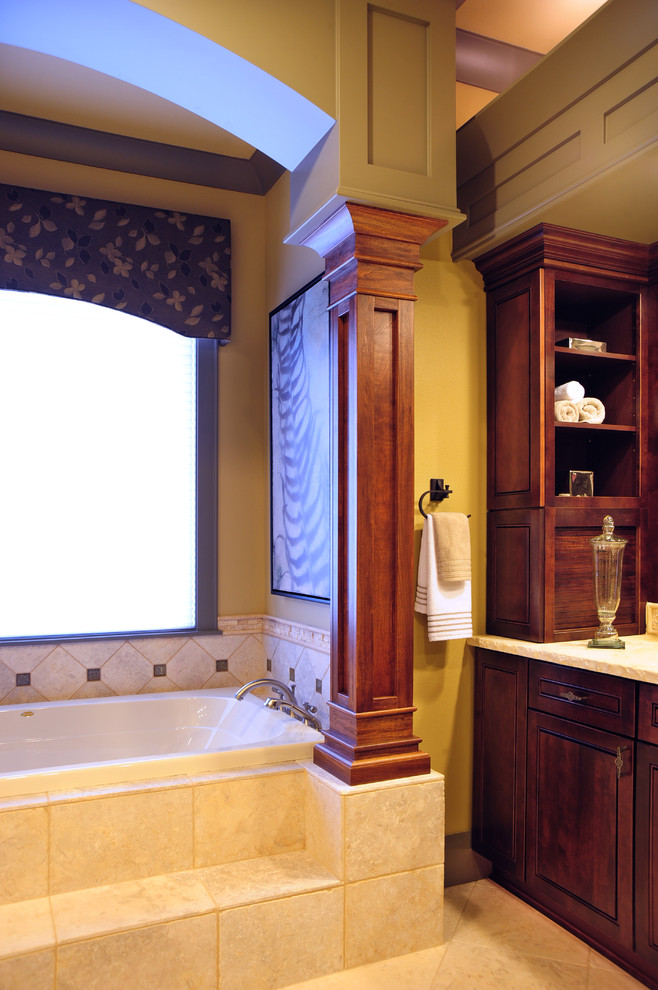 Идея дизайна: большая главная ванная комната в современном стиле с врезной раковиной, темными деревянными фасадами, столешницей из известняка, ванной в нише, бежевой плиткой, терракотовой плиткой, желтыми стенами, полом из терракотовой плитки, фасадами с утопленной филенкой, унитазом-моноблоком, бежевым полом и душем с распашными дверями