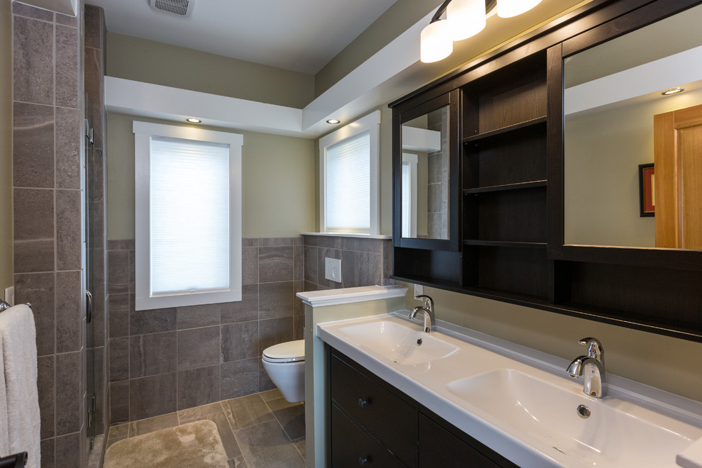 Idéer för att renovera ett mellanstort vintage en-suite badrum, med släta luckor, svarta skåp, en dusch i en alkov, en vägghängd toalettstol, grå kakel, keramikplattor, gröna väggar, klinkergolv i keramik, ett integrerad handfat, bänkskiva i akrylsten och brunt golv